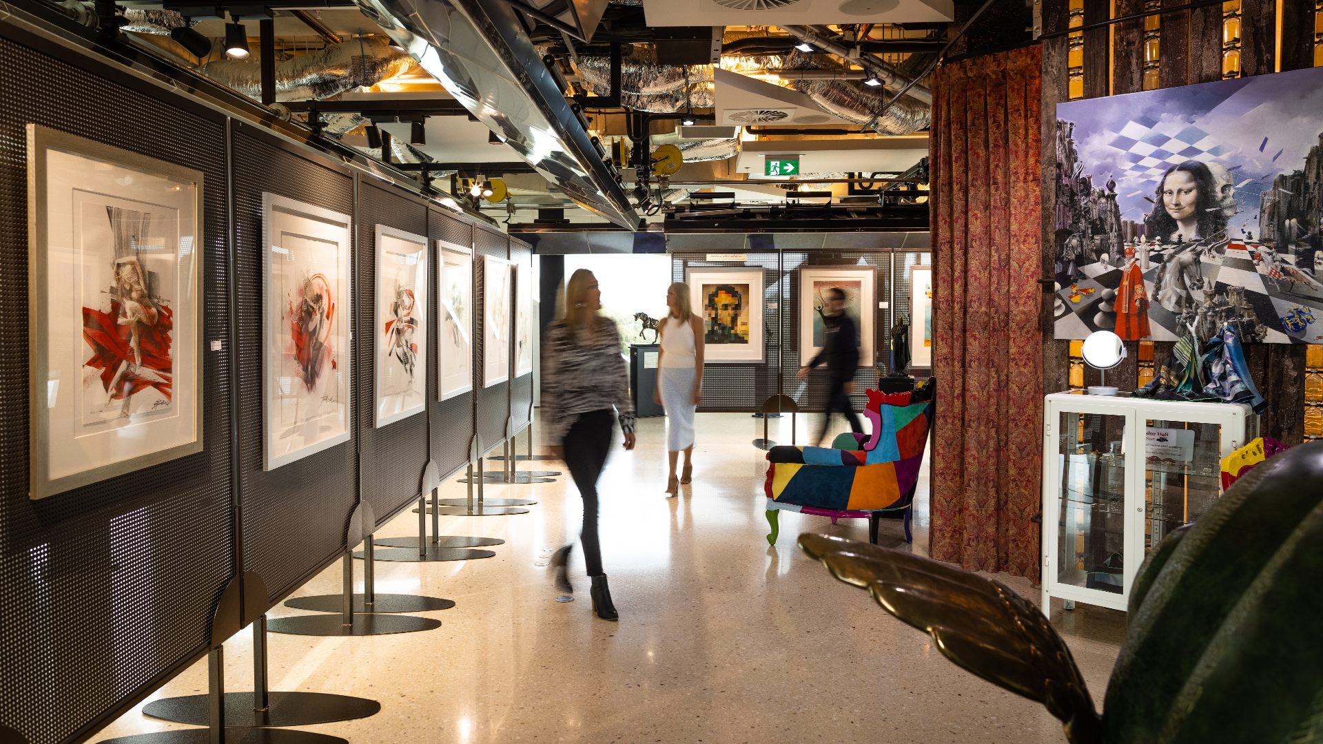 People walking and looking at art work in a modern building.